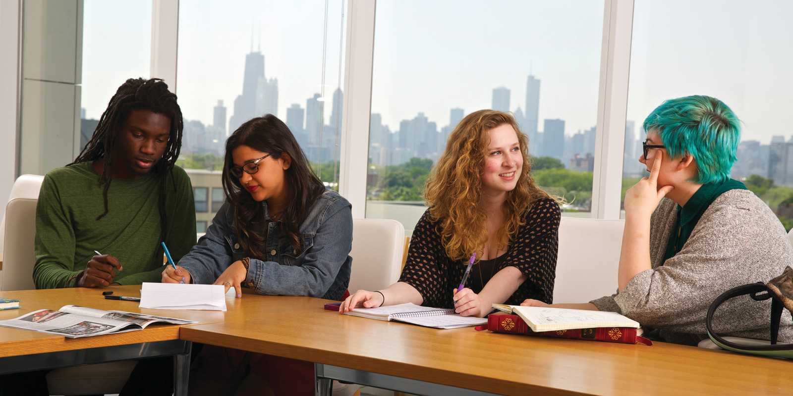 Students reviewing class notes behind the Chicago skyline.