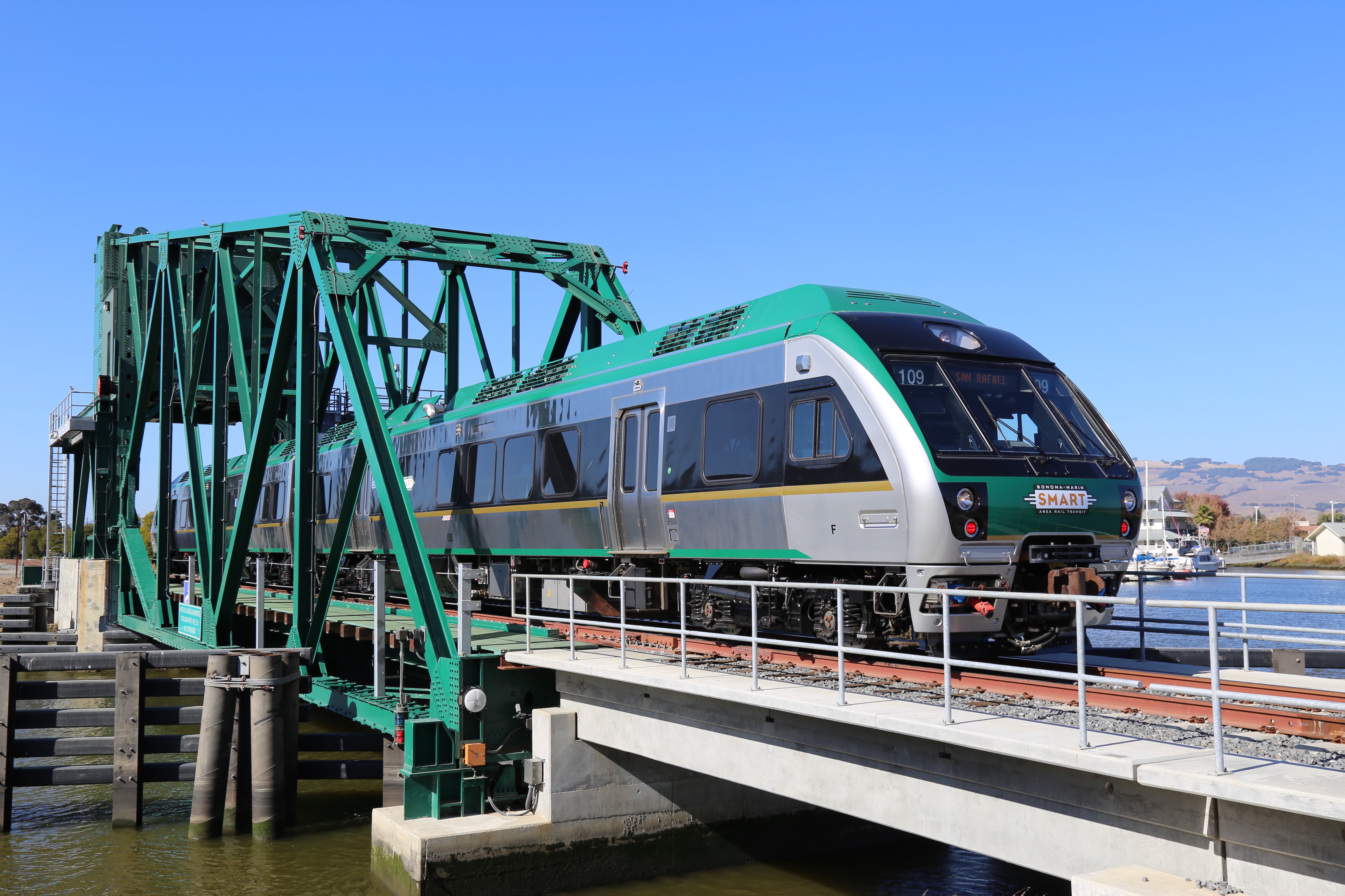 green train crossing bridge